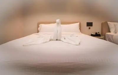 a white bed with white sheets and white pillows at Hotel Shellmark in Elivāla