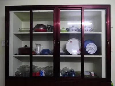 a glass cabinet filled with dishes and other items at Eden luxury stay saravanampatti in Coimbatore