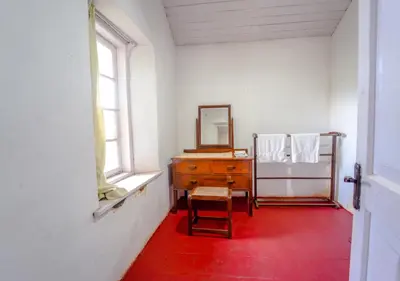a room with a dresser and a mirror and a chair at Arivikad Tea Bungalow Munnar By VOYE HOMES in Munnar