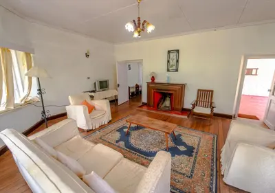 a living room with white furniture and a fireplace at Arivikad Tea Bungalow Munnar By VOYE HOMES in Munnar