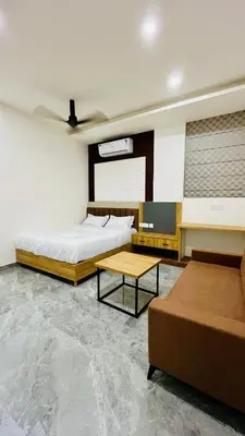 a bedroom with two beds and a table in it at Fargo Hotels in Kozhikode