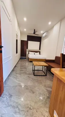 a room with two beds and a table in it at Fargo Hotels in Kozhikode