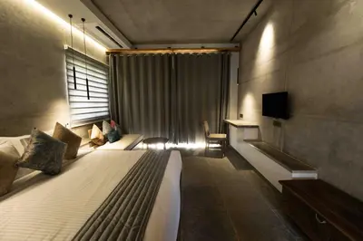 a bedroom with two beds and a window with a television at Wild Origin Kabini - A Luxury Resort in Kabini River