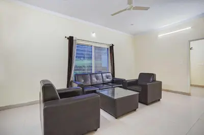 a living room with leather furniture and a window at Collection O Mysore Shri Lakshmikantha Swamy Temple in Mysore