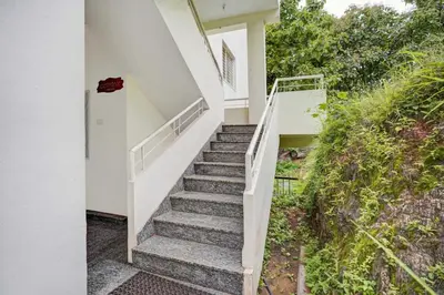 a staircase leading up to a white house at Collection O Mysore Shri Lakshmikantha Swamy Temple in Mysore