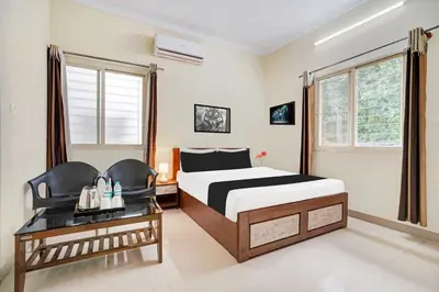 a hotel room with a bed and a desk and window at Collection O Mysore Shri Lakshmikantha Swamy Temple in Mysore