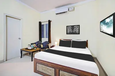 a bedroom with a bed and a table and chairs at Collection O Mysore Shri Lakshmikantha Swamy Temple in Mysore