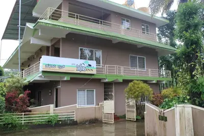a pink house with a sign on it at Safari Inn in Kurchi
