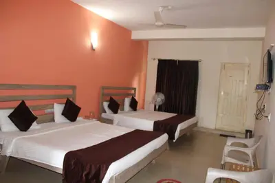 a hotel room with two beds and a window at Safari Inn in Kurchi