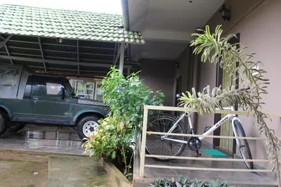 a bike parked next to a house with a truck at Safari Inn in Kurchi