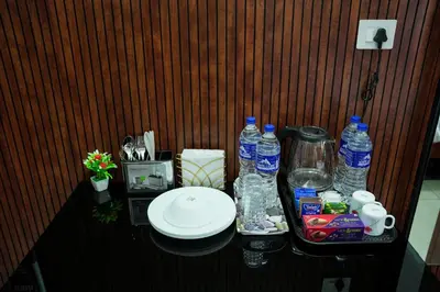 a table with bottles of water and a plate on it at TREE 9 COCHIN AiRPORT HOTEL in Nedumbassery