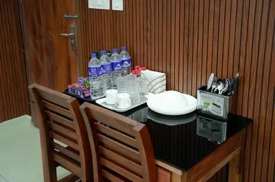 a table with a bottle of water and two chairs at TREE 9 COCHIN AiRPORT HOTEL in Nedumbassery
