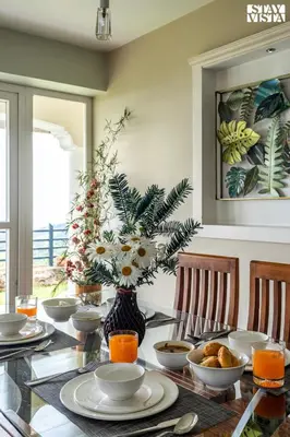 a dining room table with a vase of flowers at StayVista at Farview Presidential Suite with Lawn, Bonfire & Bathtub in Kotagiri