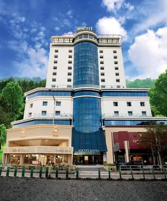 a large building with a glass facade at Ascot Hotel Calicut in Calicut