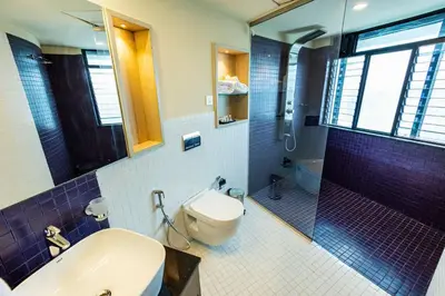 a bathroom with a toilet and a sink and a shower at Ascot Hotel Calicut in Calicut