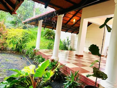 a porch of a house with a checkered floor at WAYANAD RESORT VILLA Service in Meppādi