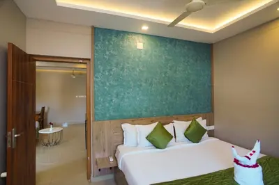 a bedroom with a bed with a green wall at Sreepathi Prayag 11 Service Apartment in Guruvāyūr