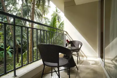 a balcony with two chairs and a table in front of a window at Sreepathi Prayag 11 Service Apartment in Guruvāyūr