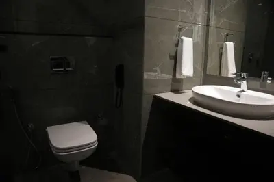 a bathroom with a white toilet and a sink at Alba Regency in Guruvāyūr
