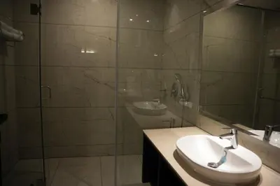 a bathroom with a sink and a glass shower at Alba Regency in Guruvāyūr