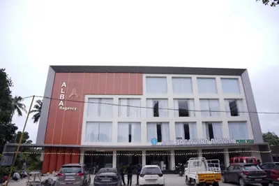 a building with cars parked in front of it at Alba Regency in Guruvāyūr