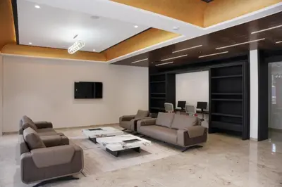 a living room with leather furniture and a flat screen tv at Alba Regency in Guruvāyūr