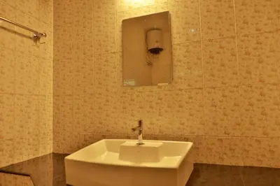 a bathroom with a sink and a mirror on the wall at Nila Heavens - Spacious 5 BHK Homestay , ideal for families in Guruvāyūr