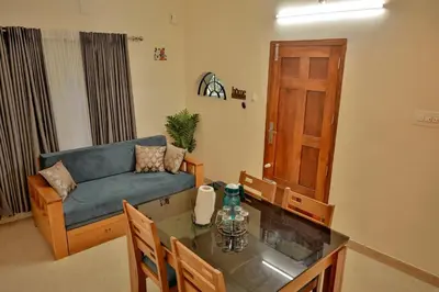 a living room with a couch and a table at Nila Heavens - Spacious 5 BHK Homestay , ideal for families in Guruvāyūr