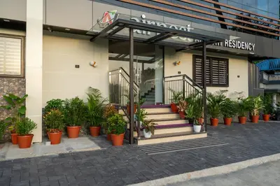 a building with potted plants in front of it at AIRNEST Airport Residency in Nedumbassery