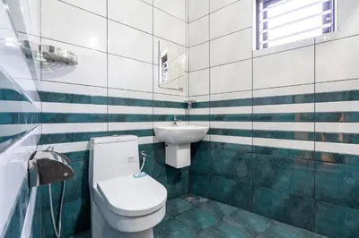 a bathroom with a toilet and a sink at AIRNEST Airport Residency in Nedumbassery