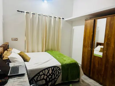 a bedroom with a bed with a laptop on it at Nirvana Stays Banasura, Wayanad in Wayanad