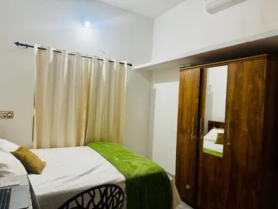 a bedroom with a bed and a wooden cabinet at Nirvana Stays Banasura, Wayanad in Wayanad