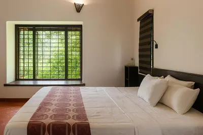 a bedroom with a large bed and a large window at Seethavanam Farmstay at Forest Edge in Kollengode