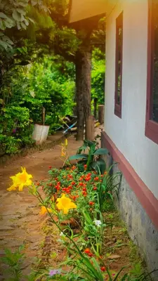 a garden with flowers next to a building at Madama Mudhouse Edenwood Retreats in Kanthalloor