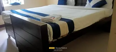 a bedroom with a large bed with a black frame at Ooty FernCrest in Ooty