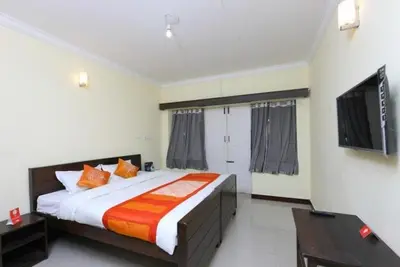 a bedroom with a large bed and a flat screen tv at Ooty FernCrest in Ooty