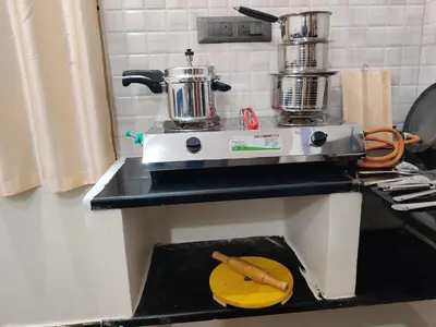 a kitchen with a juicer and a cutting board on a counter at Kamadhenu Homestay, Comapact 1BHK OPP Mysore zoo, in Mysore