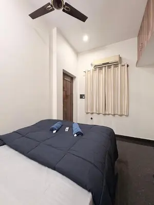 a bedroom with a bed with a ceiling fan at Kamadhenu Homestay, Comapact 1BHK OPP Mysore zoo, in Mysore