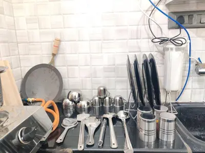 a kitchen counter top with utensils and utensils at Kamadhenu Homestay, Comapact 2BHK OPP Mysore zoo, A in Mysore