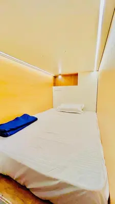 a bedroom with a white bed with a blue blanket at LF Easybeds in Kozhikode