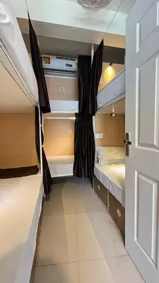 a bedroom with two bunk beds and a door at Lowfare Hotels Medical College in Kozhikode