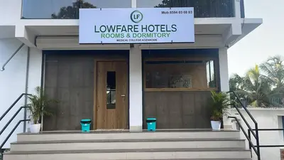 a building with a sign that reads louvre hotels rooms and bathroom at Lowfare Hotels Medical College in Kozhikode