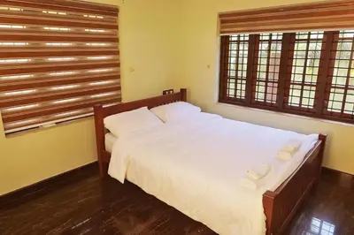 a bedroom with a large bed with white sheets and pillows at Niki Haven in Kāladi