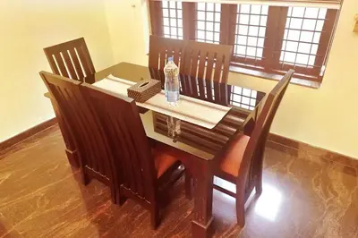 a wooden table with chairs and a bottle of water on it at Niki Haven in Kāladi