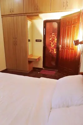 a bedroom with a bed and a door with a mirror at Niki Haven in Kāladi