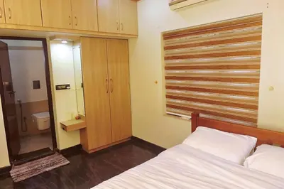 a bedroom with a bed and a toilet and a window at Niki Haven in Kāladi
