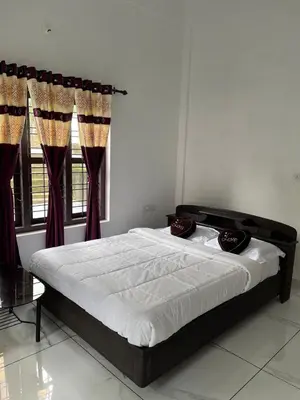 a bedroom with a large bed with red curtains at Wayanad Evergreen Farmhouse in Sultan Bathery