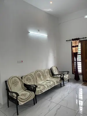 a living room with a couch and two chairs at Wayanad Evergreen Farmhouse in Sultan Bathery
