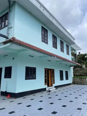 a house with blue paint and a courtyard at Wayanad Evergreen Farmhouse in Sultan Bathery