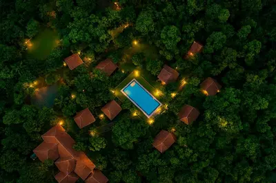 an overhead view of a pool in a forest at night at The Crescent Wayanad Heritage Pool Resort in Sultan Bathery